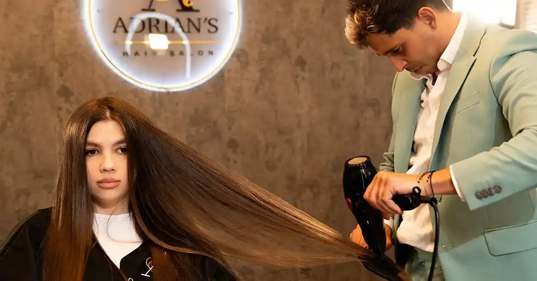 Stylist working with a flat iron on Leslie's long, beautiful hair as part of the 'Efecto Espejo' treatment process, enhancing its shine and smoothness.